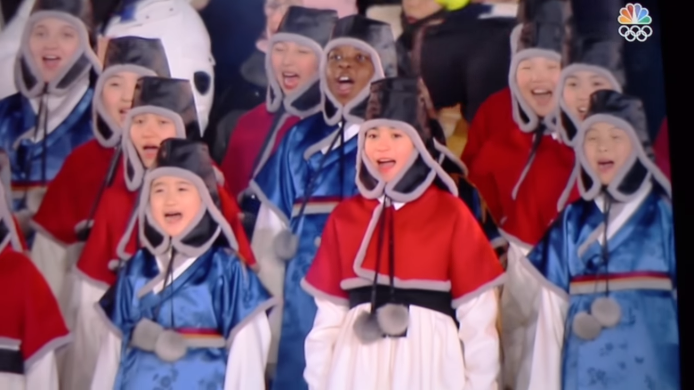 Children from different races sing the South Korean national anthem in traditional clothes.