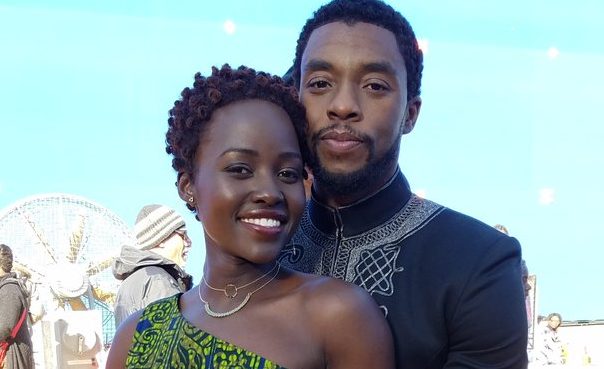 Lupita Nyong'o and Chadwick Boseman pose together in an embrace during a behind-the-scenes moment in Black Panther