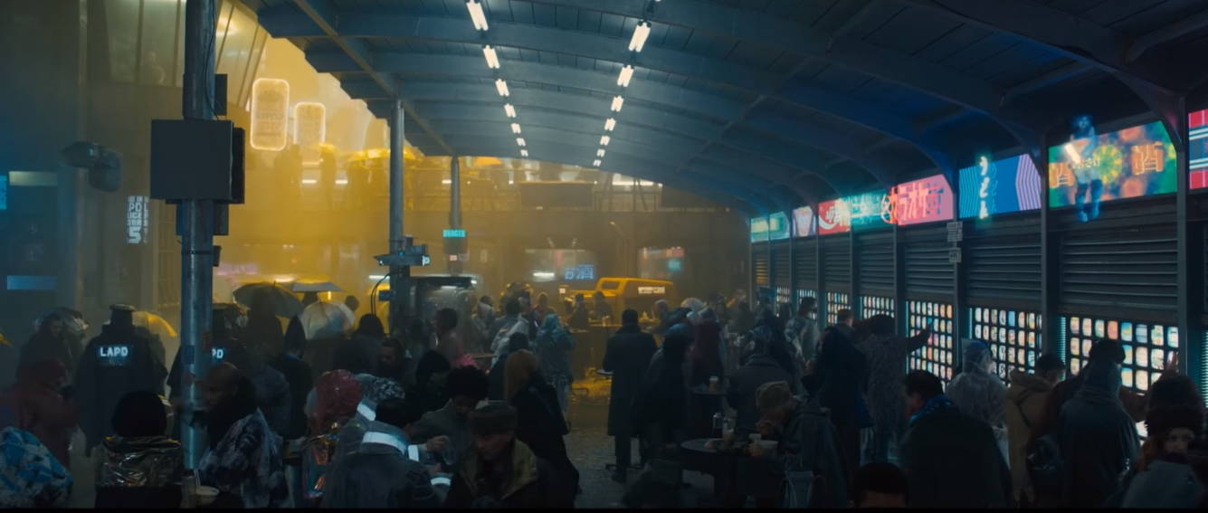 A soot-covered Chinatown in Blade Runner: 2049. Loud and colorful advertisements act as a contrast to the bleak scene.