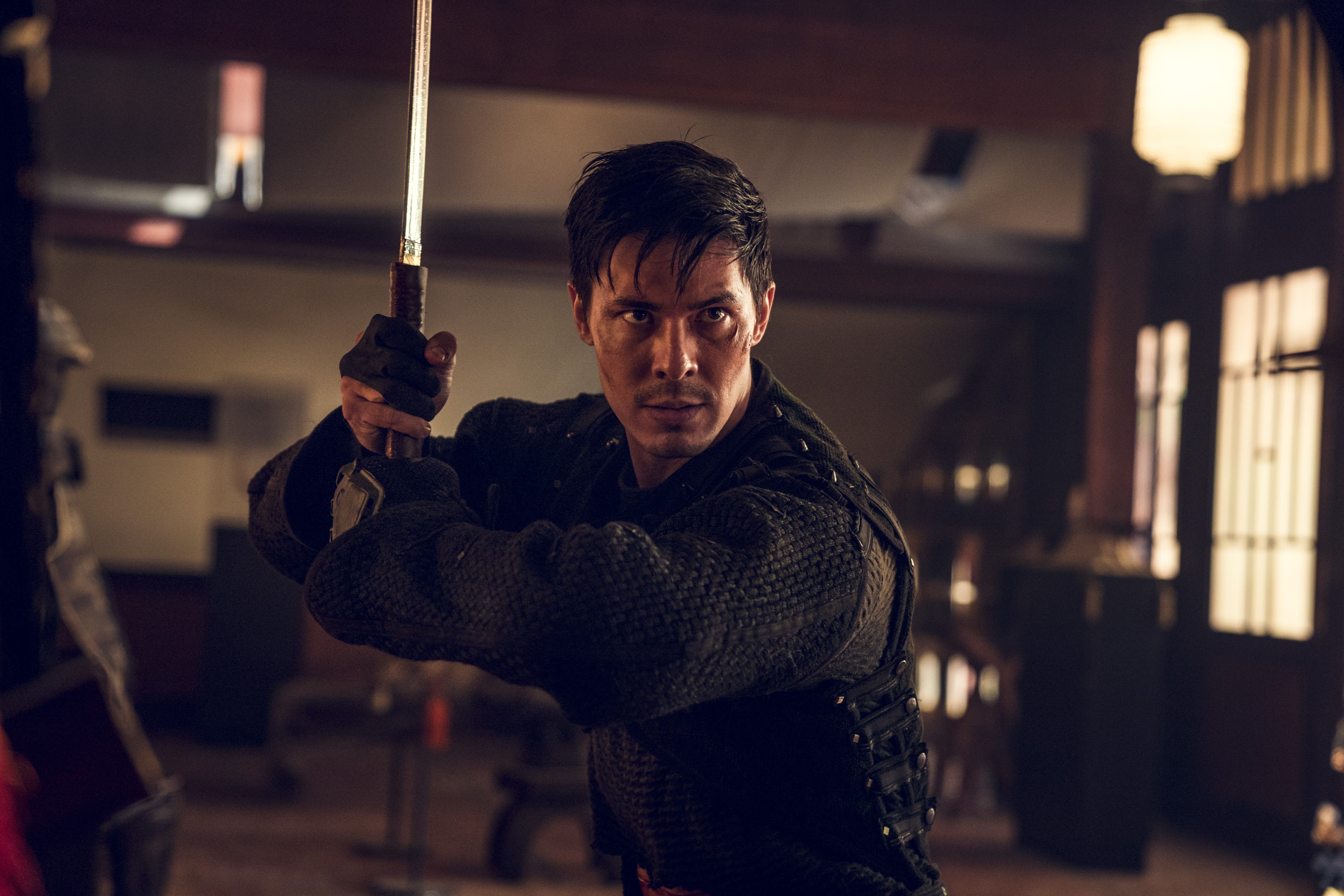 Lewis Tan as Gaius. He's holding a katana and black ninja clothes. 