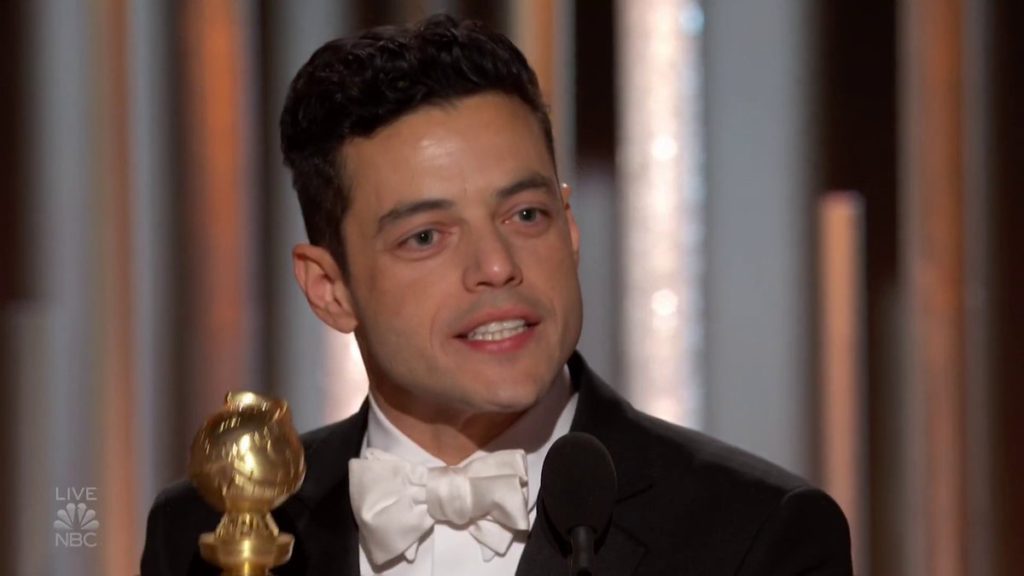 Rami Malek in a black tux with white dress shirt and white satin bow time, accepts his award. Of course, he looks dreamy. 
