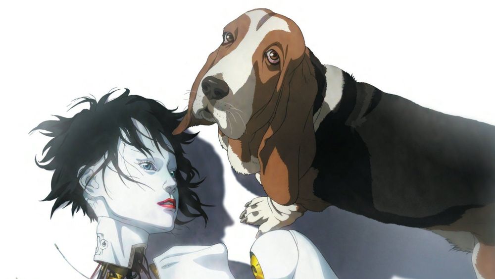 A broken female robot with white skin, blue eyes, black hair and red lipstick looks to the side as a black, brown and white bassett hound looks to the camera. They are in front of a white background. 