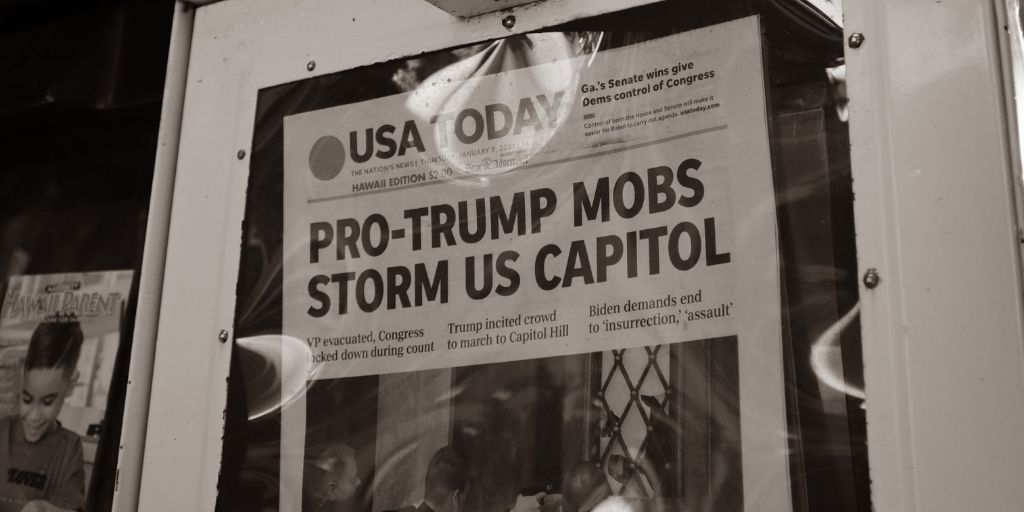 Newspaper reads "Pro-Trump Mobs Storm US Capitol." (Photo credit: little plant on Unsplash)